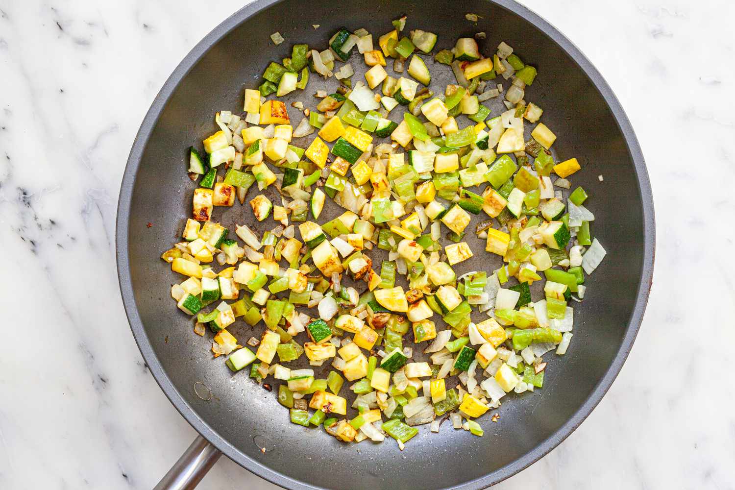 Diced vegetables in a skillet to show how to make tacos.