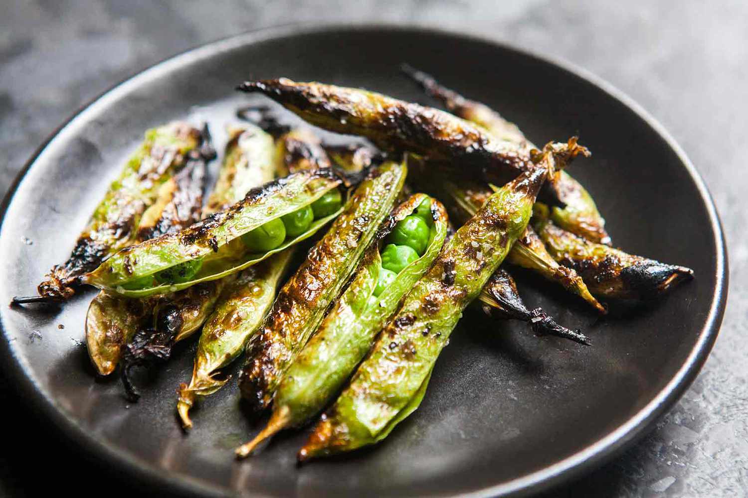 Grilled english peas on a plate, ready to eat.