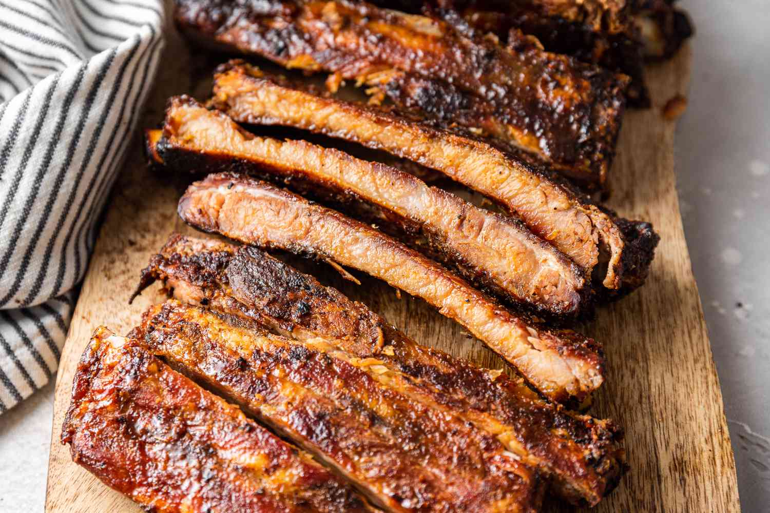 Memphis-Style Pork Ribs Cut into Pieces on a Wooden Plank
