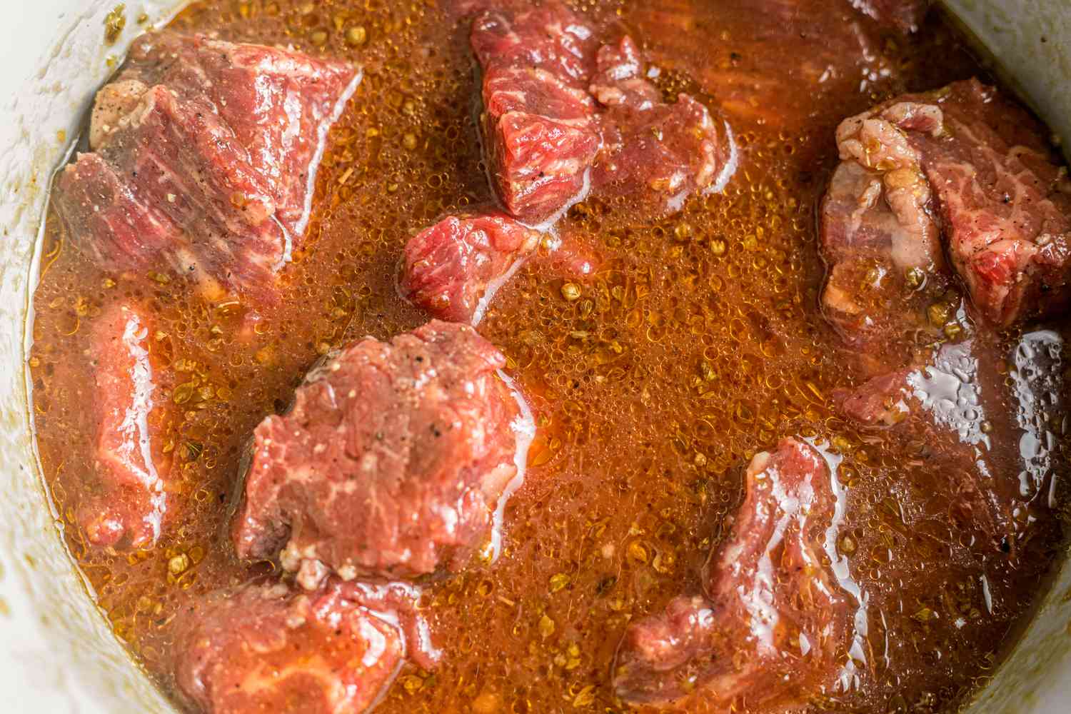 Steak tips marinating in the bowl of marinade