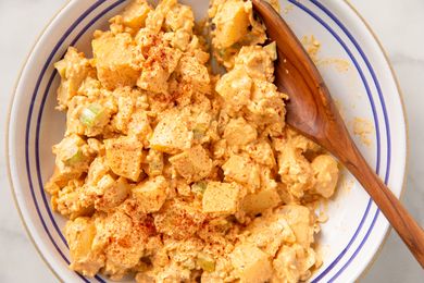 overhead view of Deviled Egg Potato Salad in a bowl with a wooden spoon