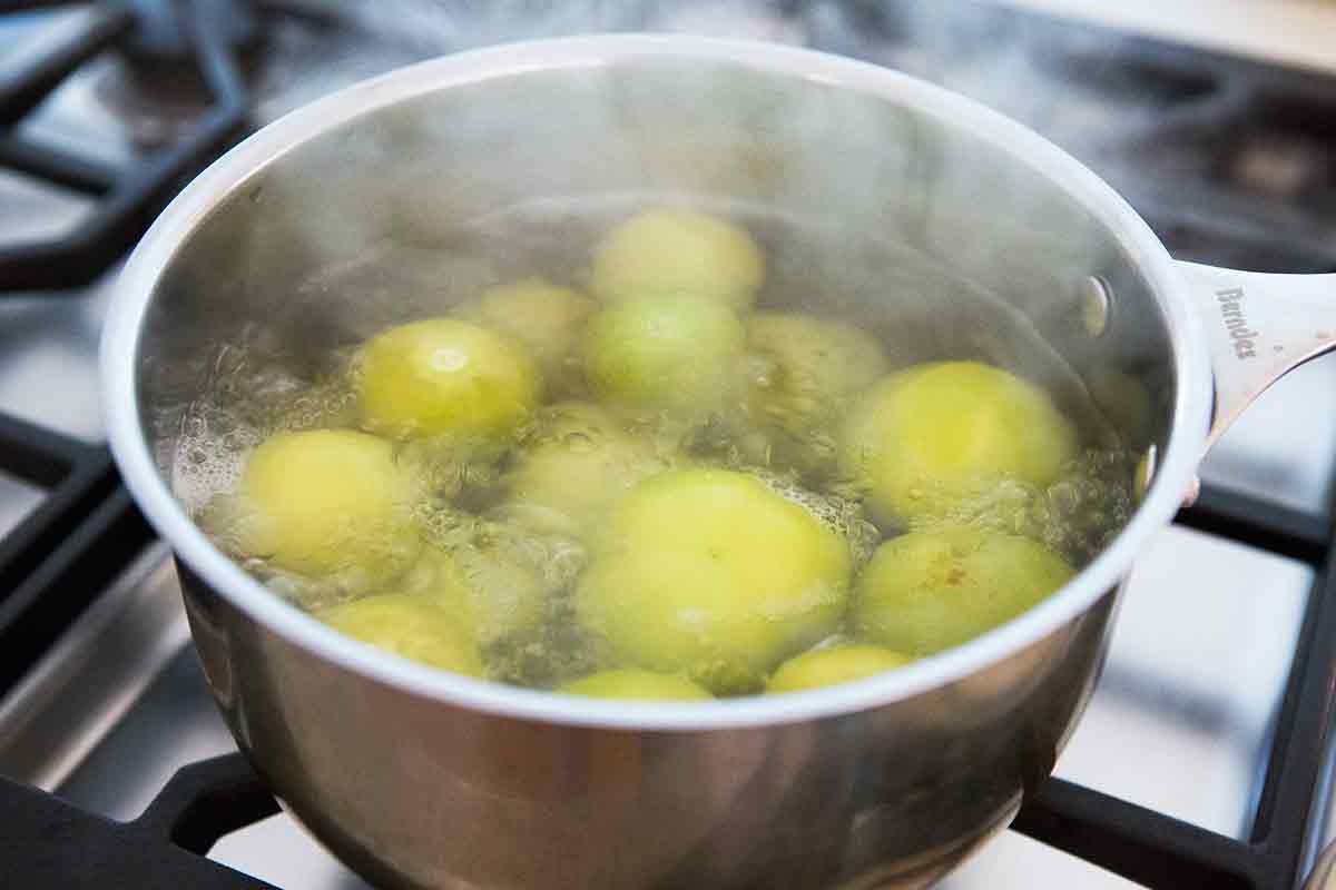 Preparing the green sauce by cooking tomatillos 