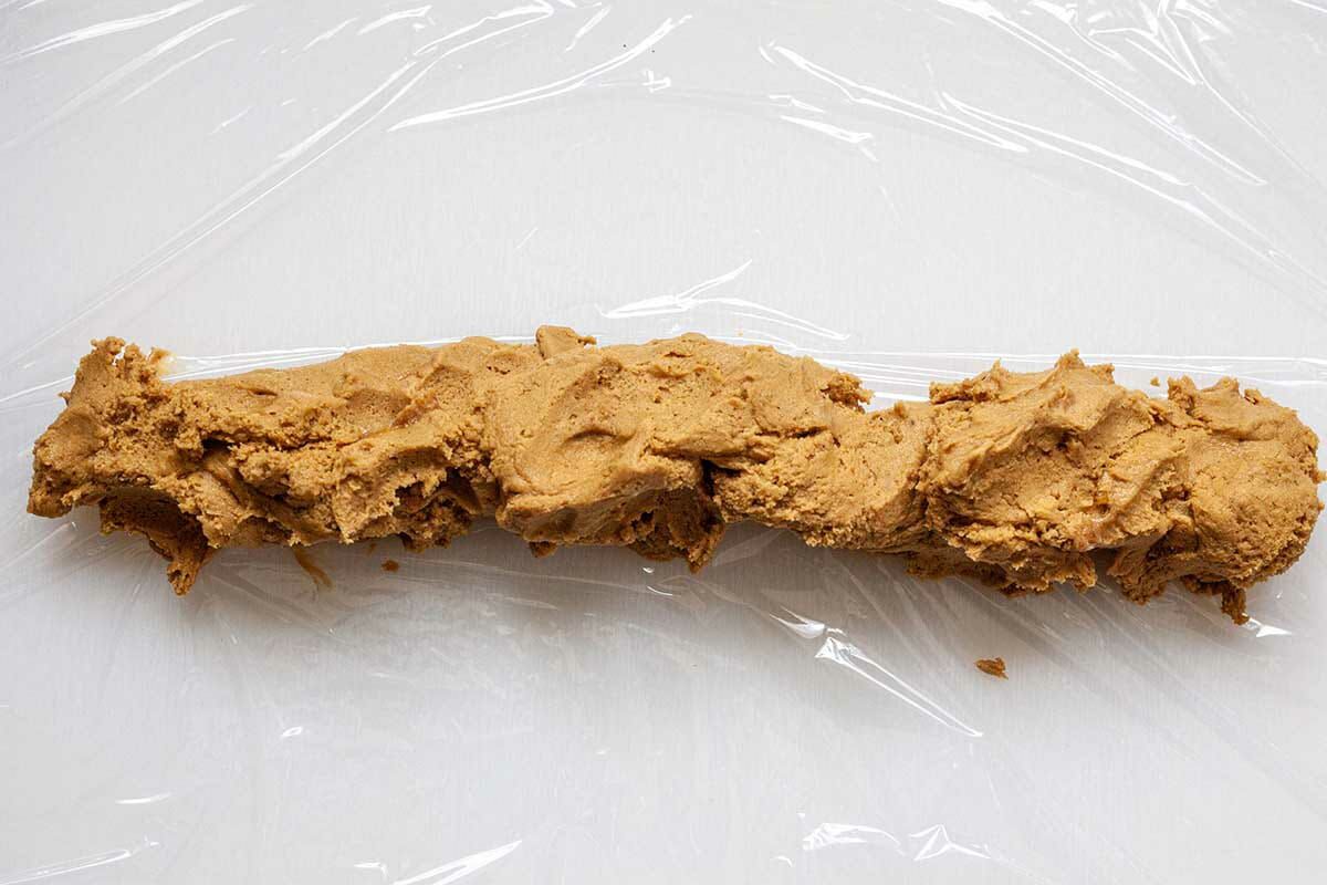 Cookie dough shaped into a log and set on plastic wrap to make Slice and Bake Ginger Cookies.