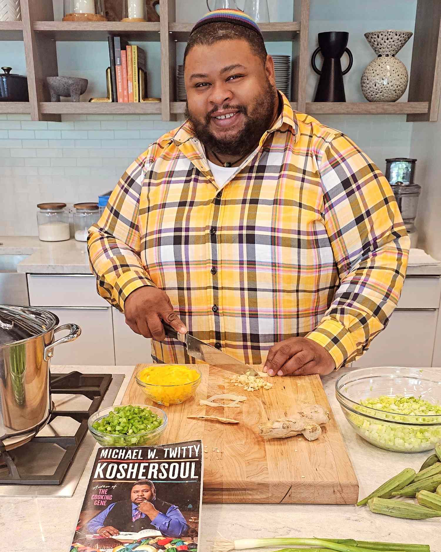 Person preparing food in a kitchen a book titled KosherSoul by Michael W Twitty on the counter