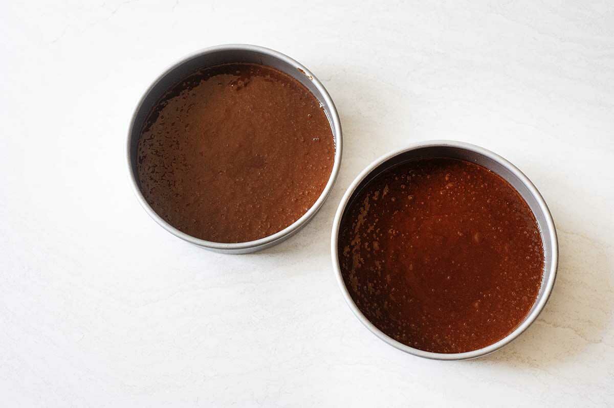 Two round cake pans filled with batter for Homemade Black Forest Cake.