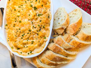 New Year’s Eve Hot Crab Dip in a dish with slices of bread