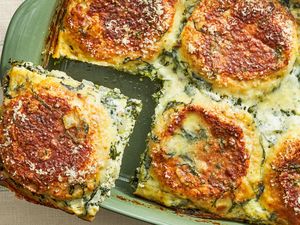 A baked spinach and cheese lasagna being served from a casserole dish