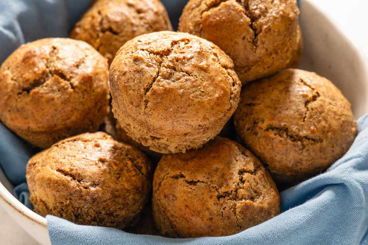 A blue cloth lined bowl with seven Six-Week Refrigerator Muffins