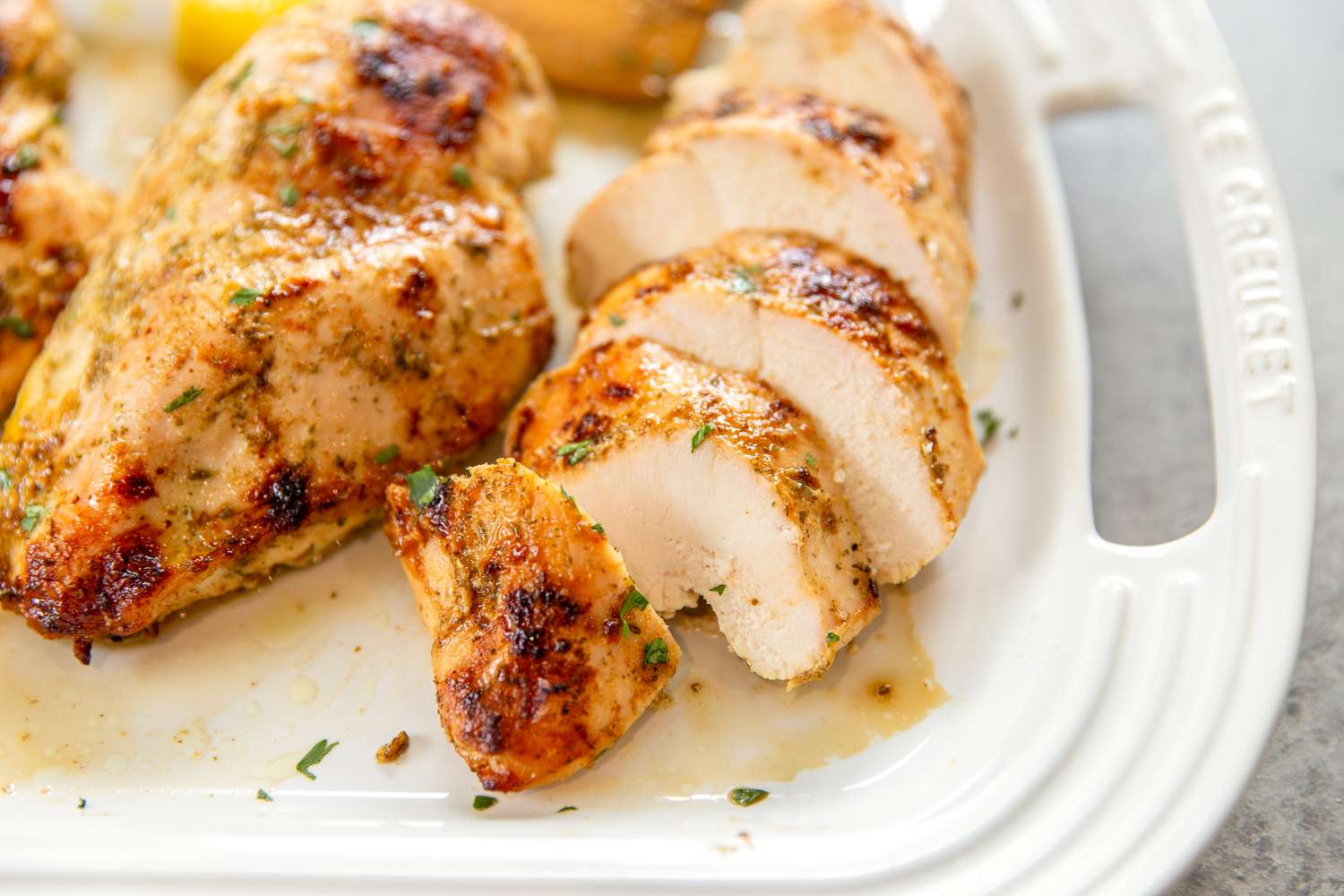Cooked chicken breasts sliced arranged on a serving dish