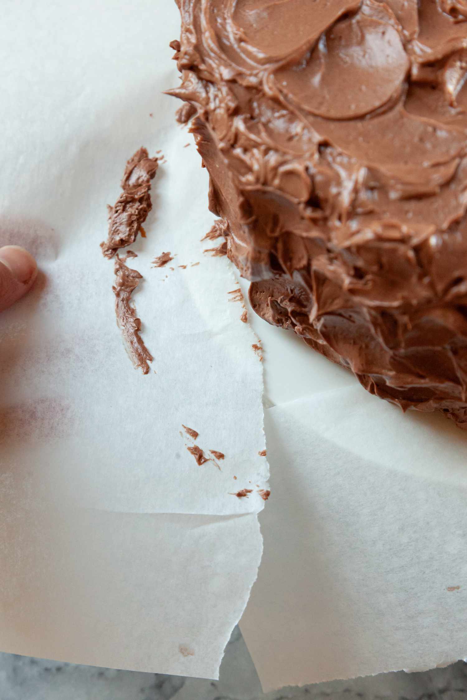 Using a paper towel to show how to frost a layer cake.