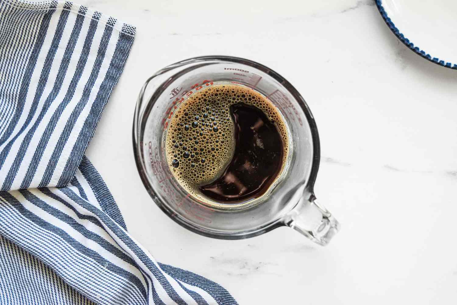 Espresso Powder Mixed with Hot Water in a Pyrex Cup for Chocolate Sheet Cake Recipe