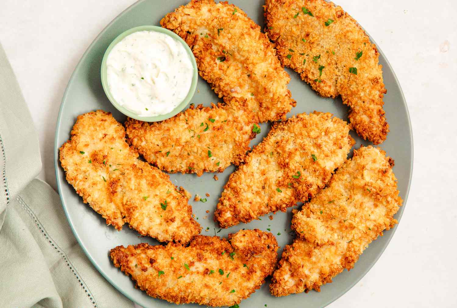 Air Fryer Chicken Tenders on a plate with ranch dip in a cup