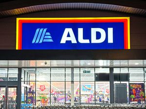 ALDI storefront at night with lit sign and visible interior