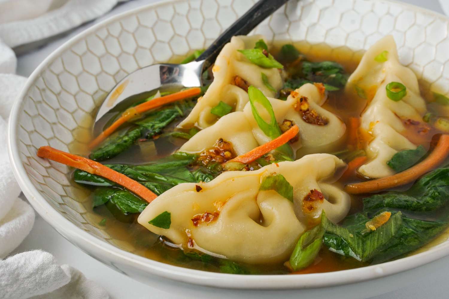 Bowl of dumpling soup with vegetables