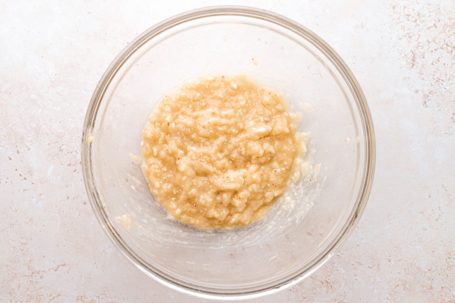 Mash bananas in a large bowl.