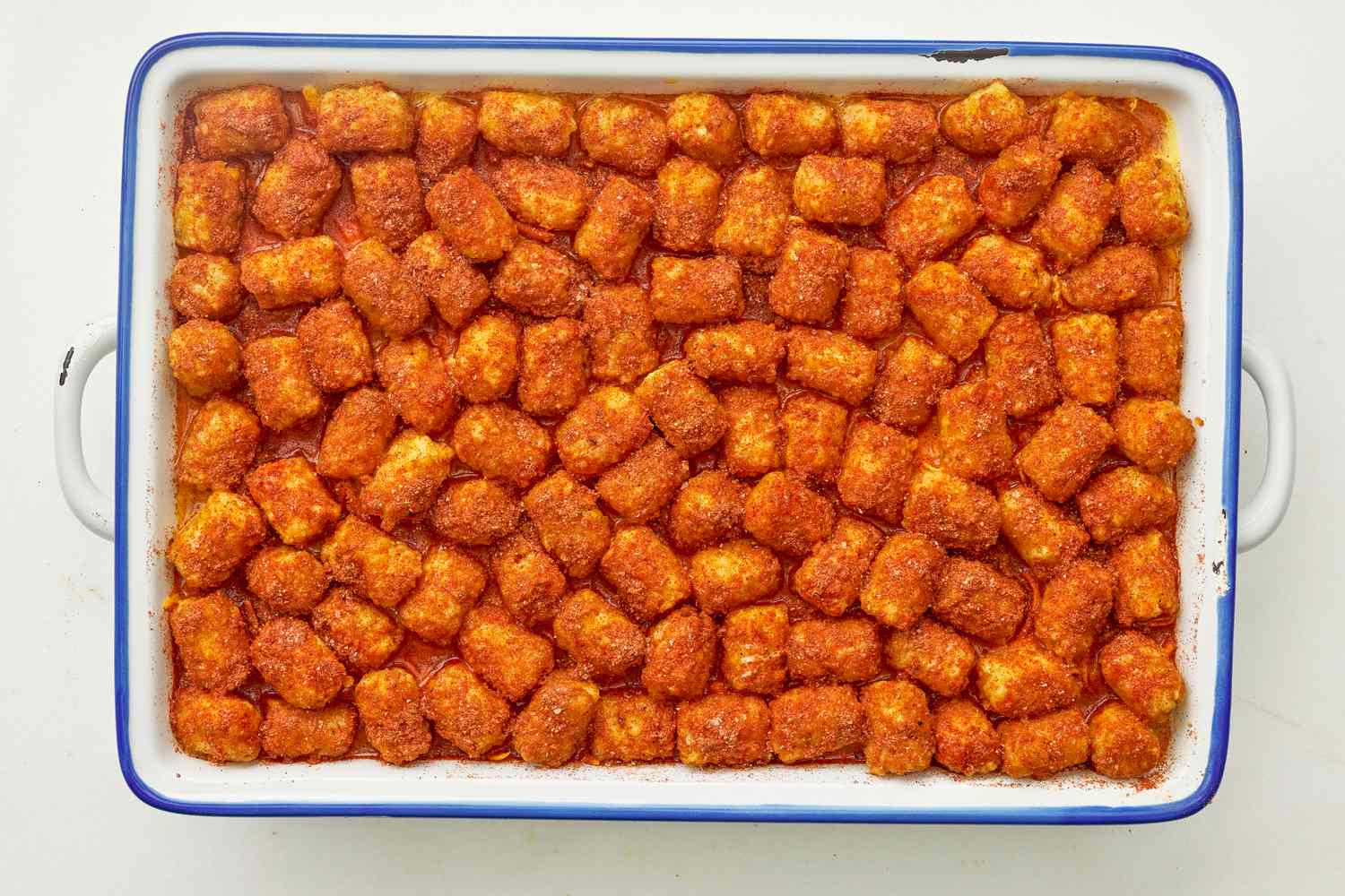 Paprika spice mix added to the tater tots in the casserol dish for corned beef tater tot casserole recipe