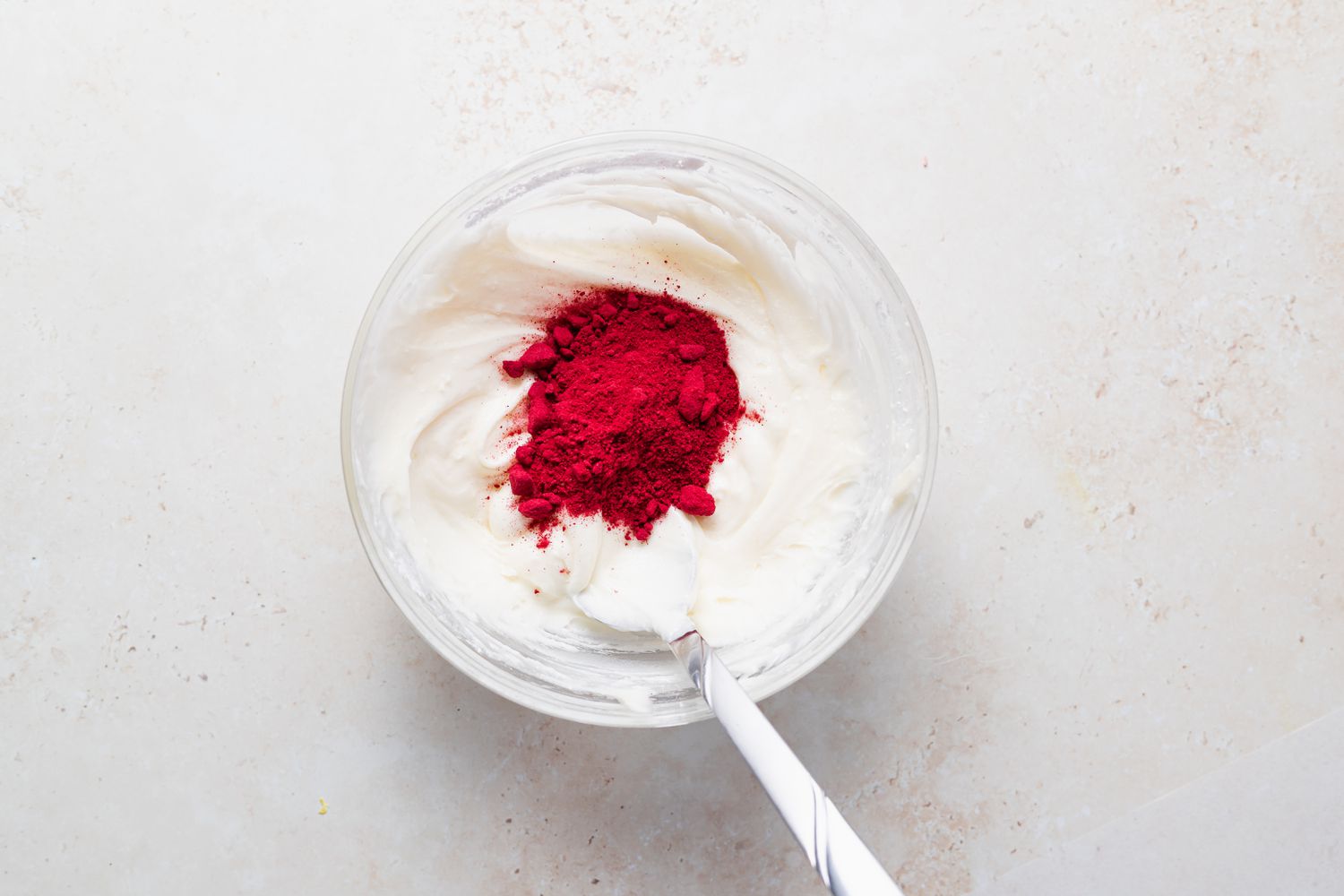 Adding raspberry powder to buttercream to make macarons.