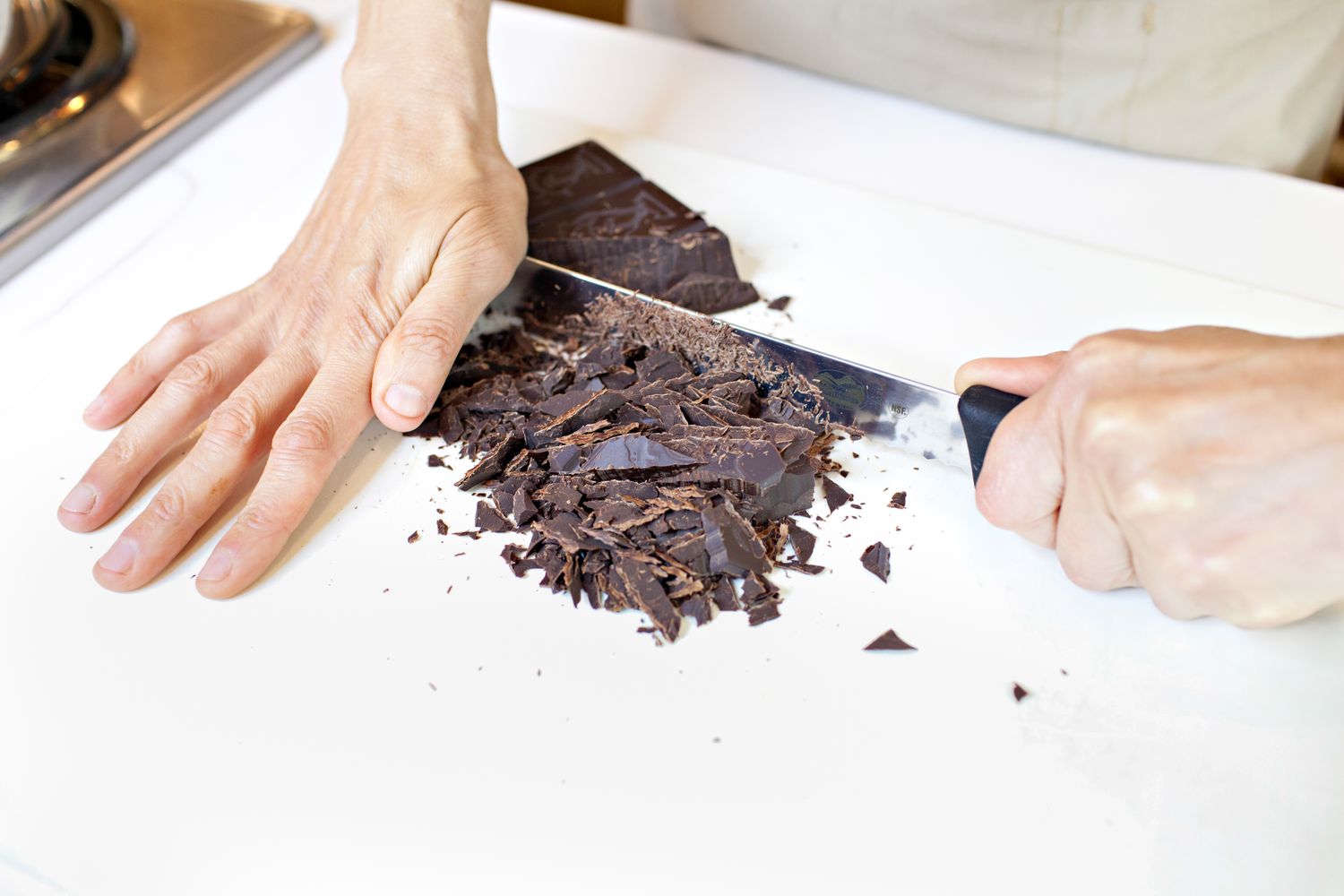 Bar of Chocolate Chopped Up on a Cutting Board for How to Temper Chocolate