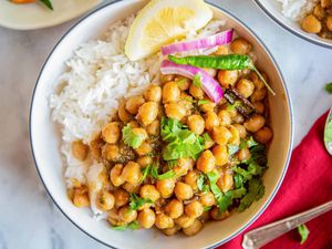 Best Chana Masala bowl of chana masala with rice, and lemon wedge