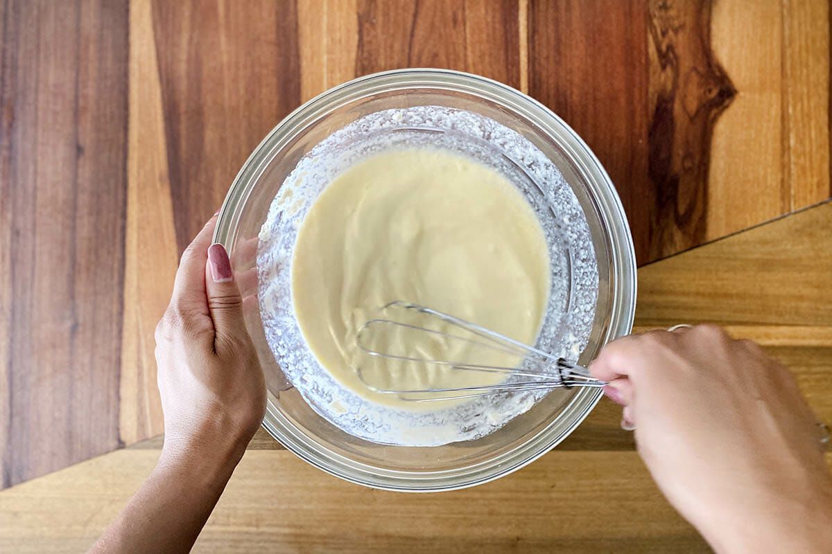Whisking ingredients to show how to make gluten free cinnamon rolls.