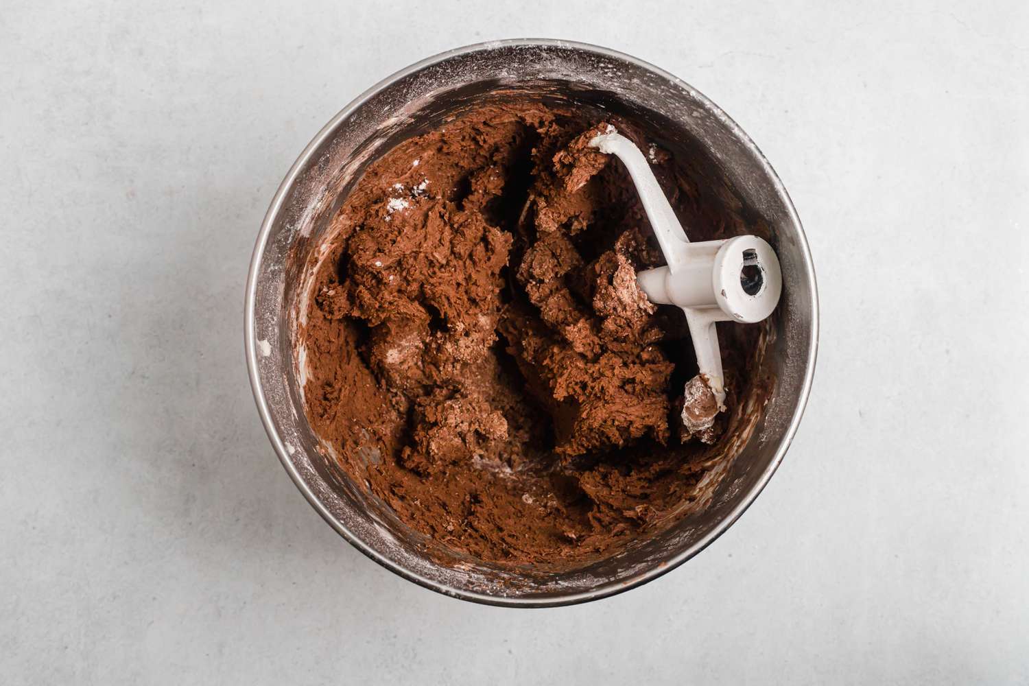 Dough to make tender chocolate butter cookies in the bowl of a stand mixer.