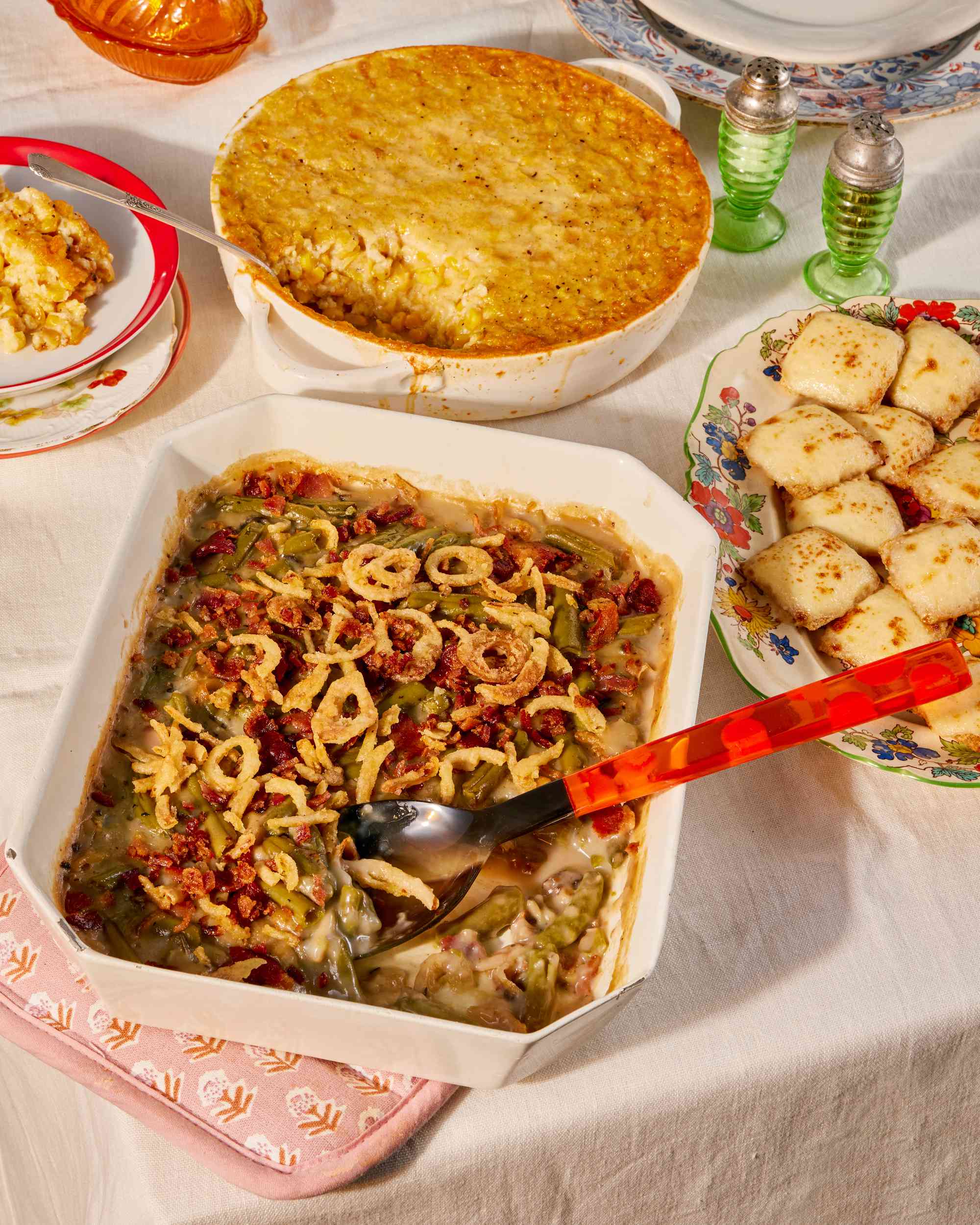 Thanksgiving table with green bean casserole, corn pudding, and triscuit crackers appetizer