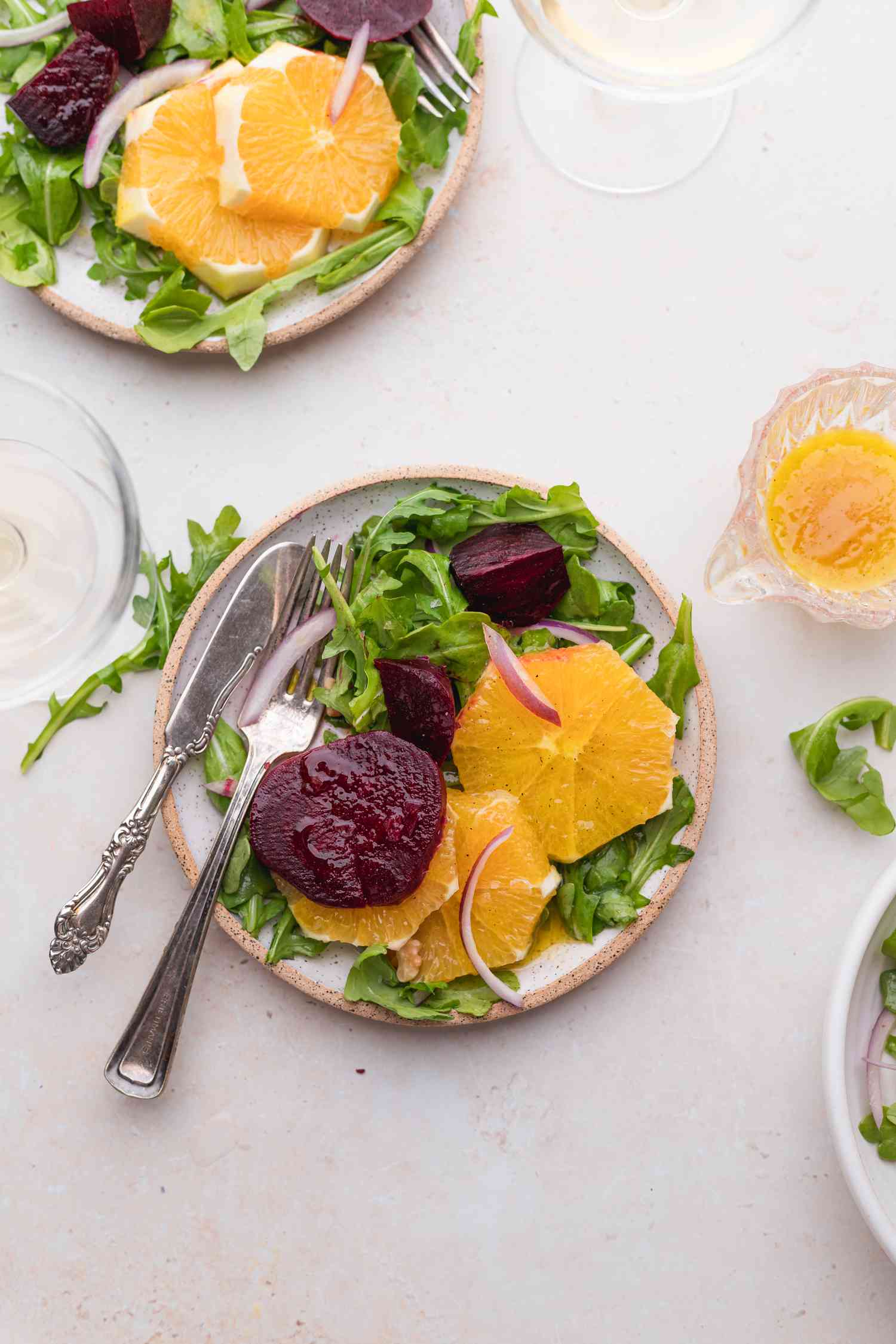 Pouring vinaigrette over a salad of beets and oranges.