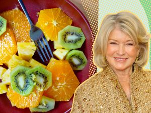 Martha Stewart next to a plate of fruit slices including kiwi, orange, and pineapple