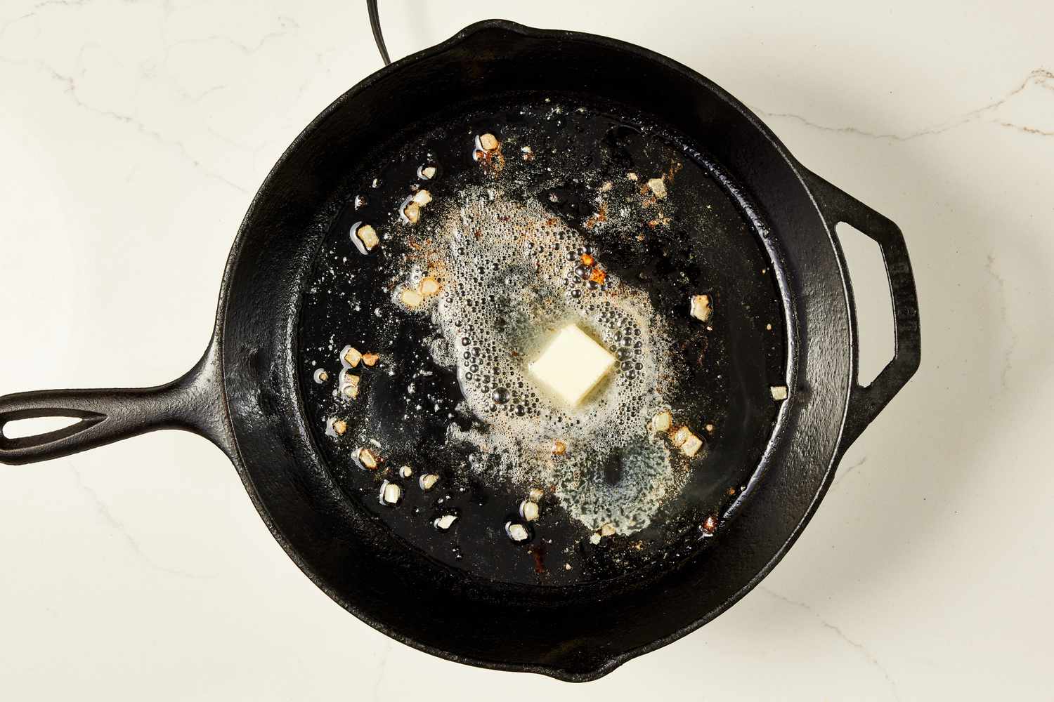Butter melting in a cast iron skillet for copycat Swedish meatballs recipe
