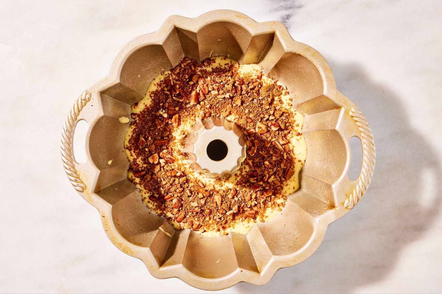 Bundt pan, batter poured in with chopped pecan mixture on top for Sock It to Me Cake