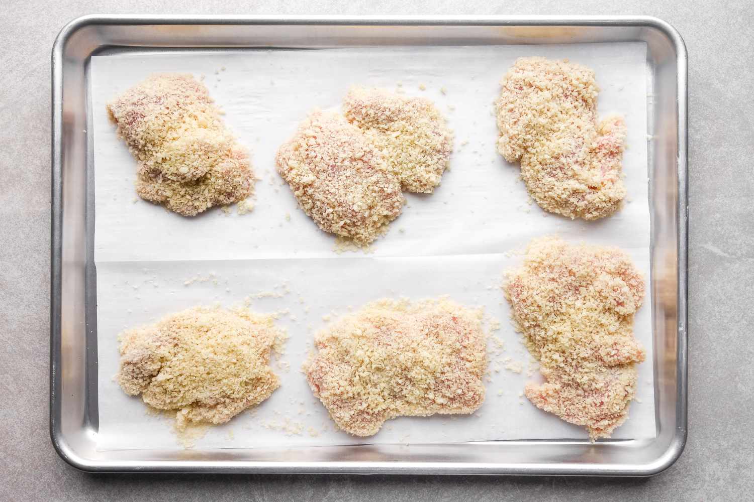Breaded chicken on sheet pan.