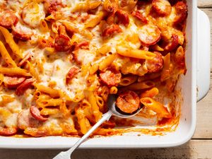 Penne and Smoked Sausage Casserole in a baking dish with a serving spoon
