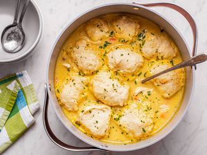 Easy Chicken and Dumplings in a pot, bowls, spoons, and napkins on the side