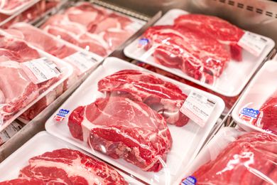 Packaged cuts of meat displayed in a store cooler