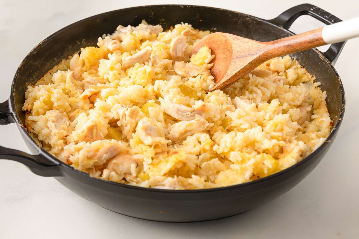 Side vew of a cast iron pot with a chicken and rice dish