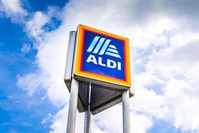 Signpole displaying Aldi logo against a cloudy sky