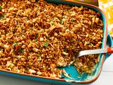 Chicken stuffing casserole in a baking dish with a serving spoon visible
