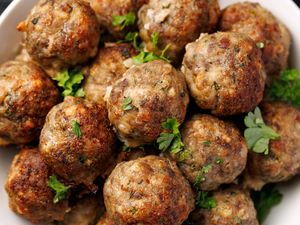 A dish of homemade meatballs garnished with parsley