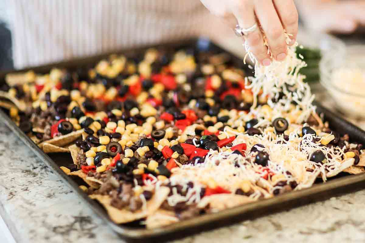 Sheet Pan Nachos with Ground Beef add the corn, black beans, olives and cheese