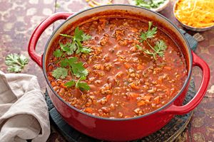 A pot of chili with cilantro garnish on top