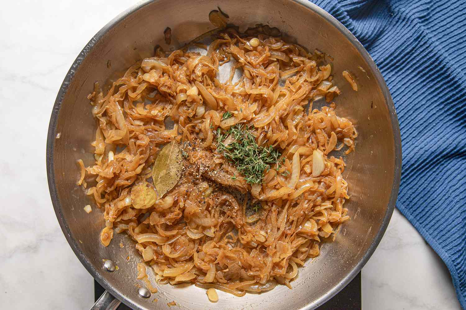 Caramelized Onions in the Pan on the Portable Stove and Seasoned With Thyme and Cracked Pepper for French Onion Meatballs Recipe