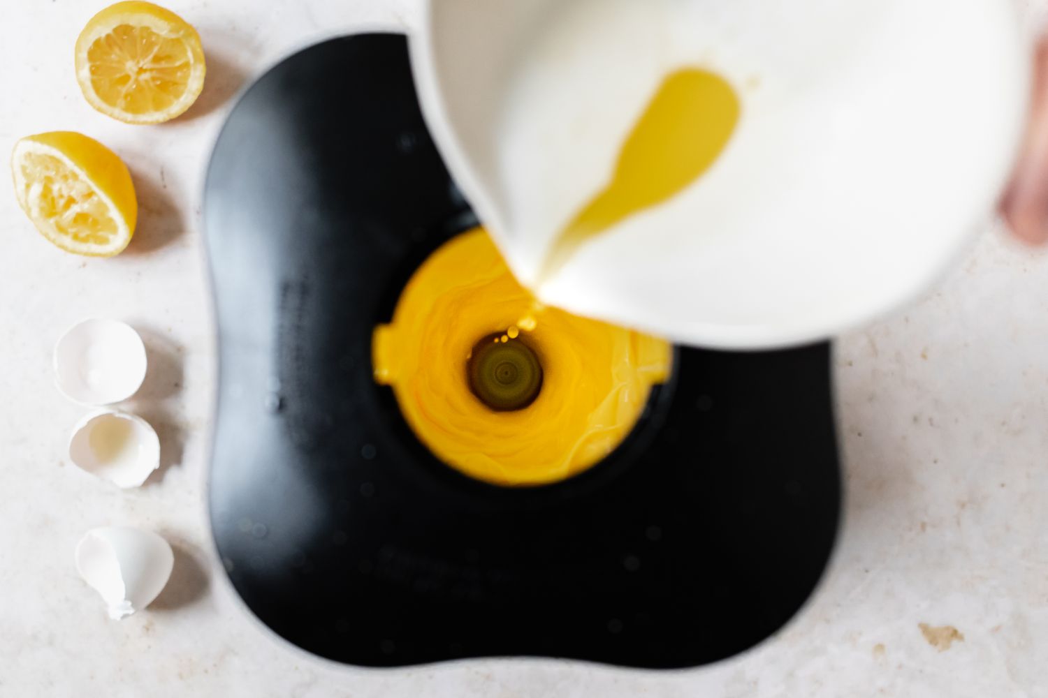Adding melted butter to egg yolks to make eggs benedict.
