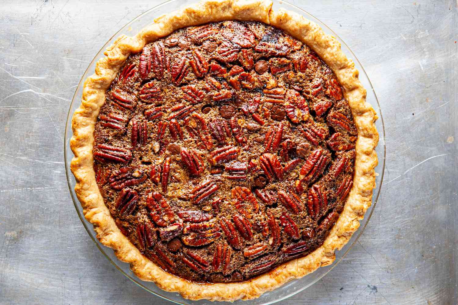 Bourbon-flavored chocolate pecan pie on a baking sheet.