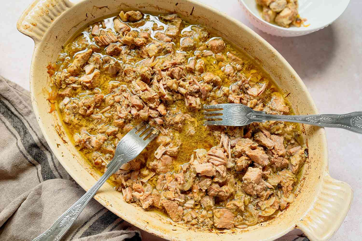 Carnitas in a Casserole Dish Shredded Using Two Forks