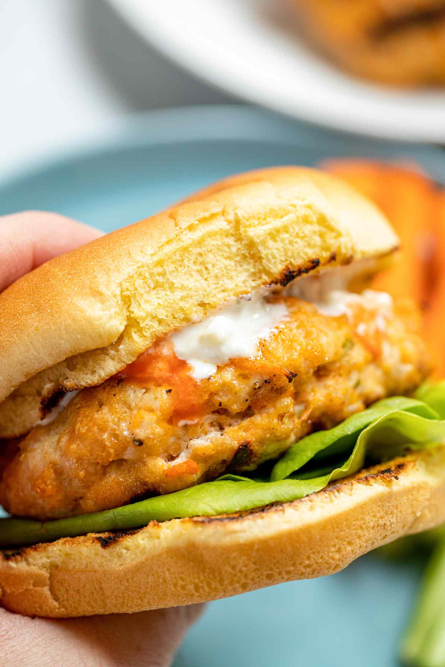 A person holding the BEST spicy buffalo chicken burger.