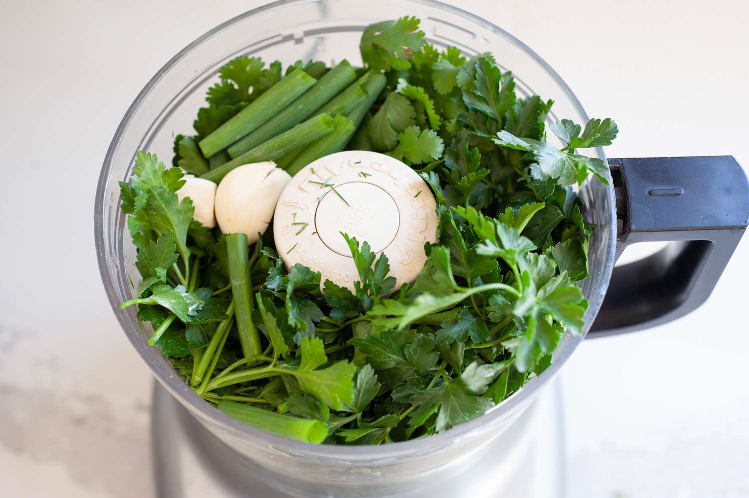 Add herbs and greens in food processor. 