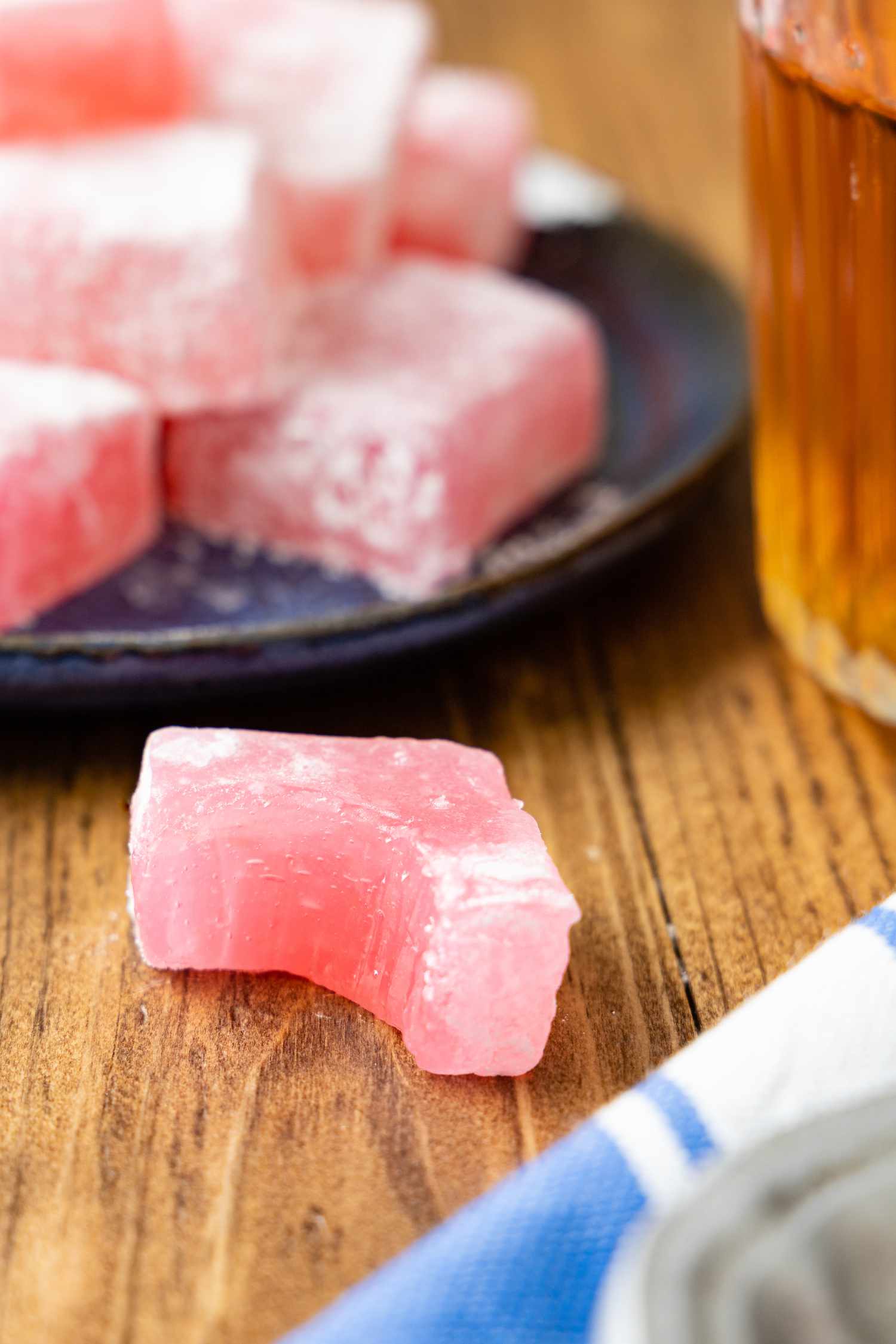 Piece of Bitten Turkish Delight on the Counter, and in the Surroundings, a Plate With More Turkish Delight, a Cup of Tea, and a Kitchen Towel