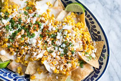Bowl of Mexican Street Corn Nachos Served With Lime Wedges