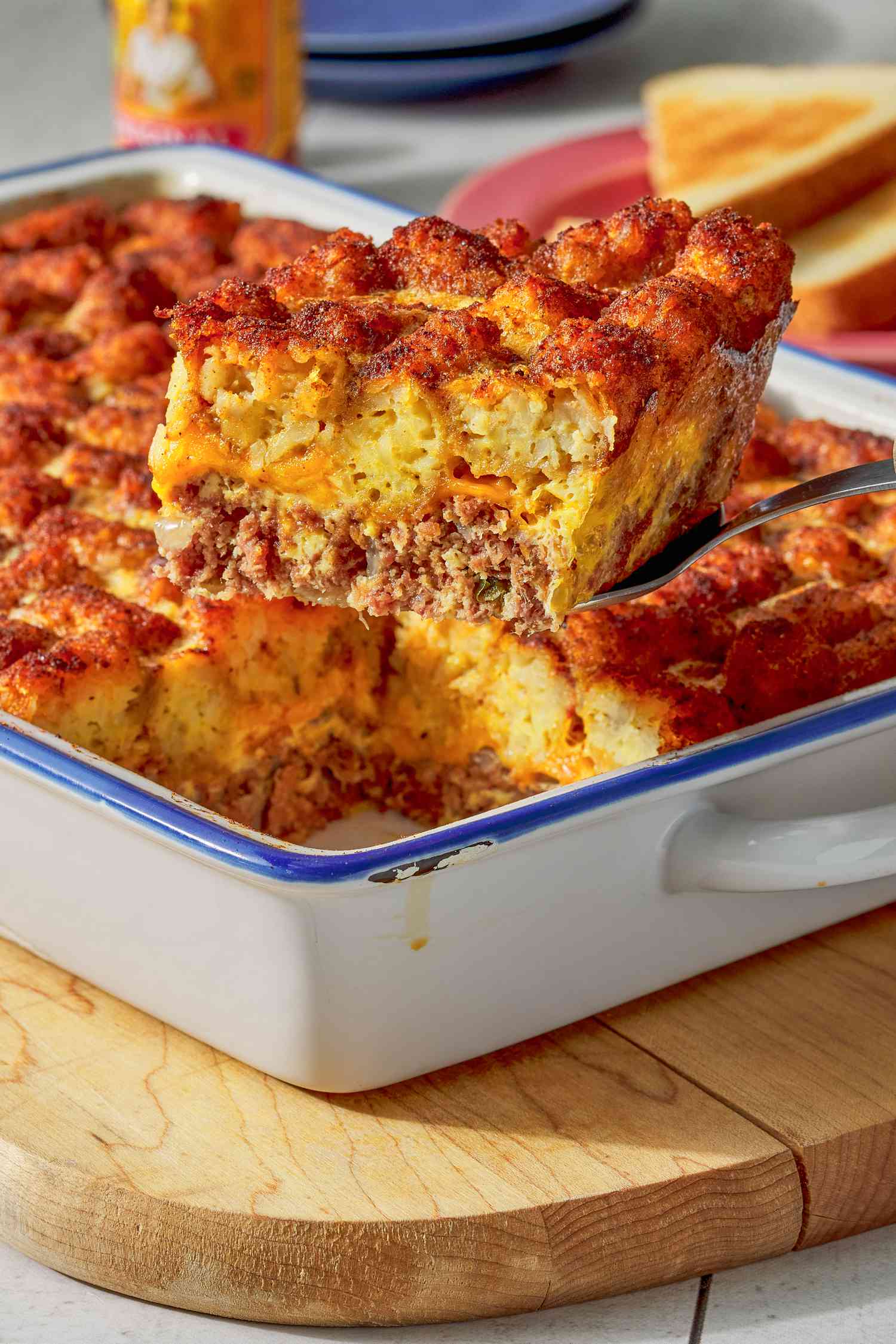 Slice of corned beef tater tot casserole raised from the casserole dish using a spatula
