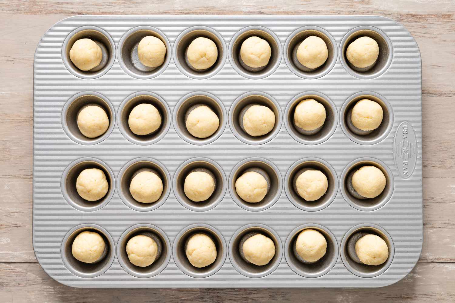 Table spoon portions of pecan pie cookie dough in a mini muffin loaf